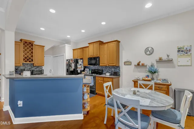 a kitchen with stainless steel appliances granite countertop a refrigerator a stove and a sink with wooden floor