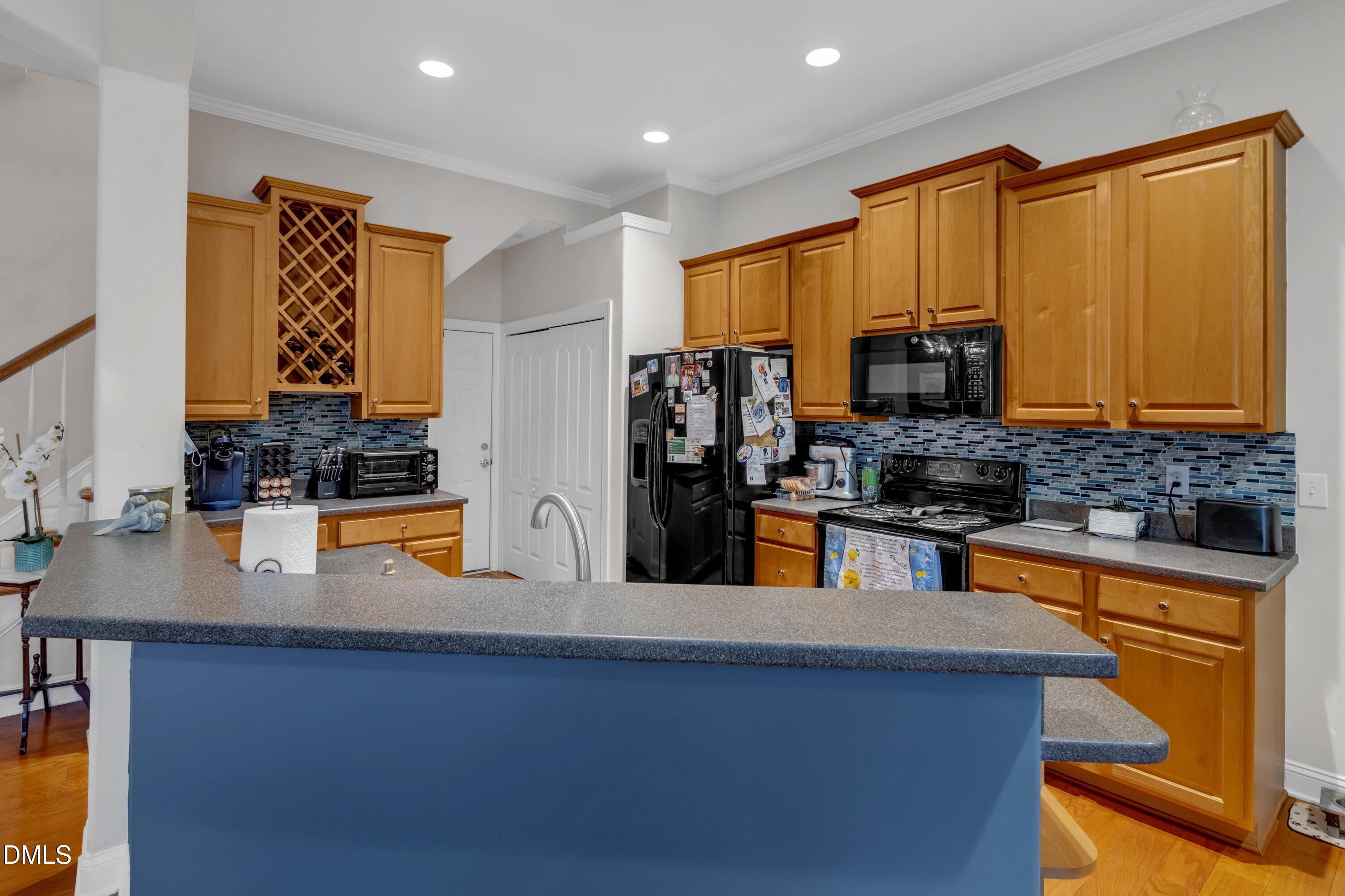 12227 Orchardgrass Lane Raleigh, NC 27614 - Photo 20 of 46 a kitchen with stainless steel appliances granite countertop a refrigerator a stove and a sink with wooden floor