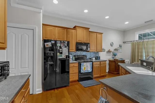 a kitchen with stainless steel appliances granite countertop a sink and a stove