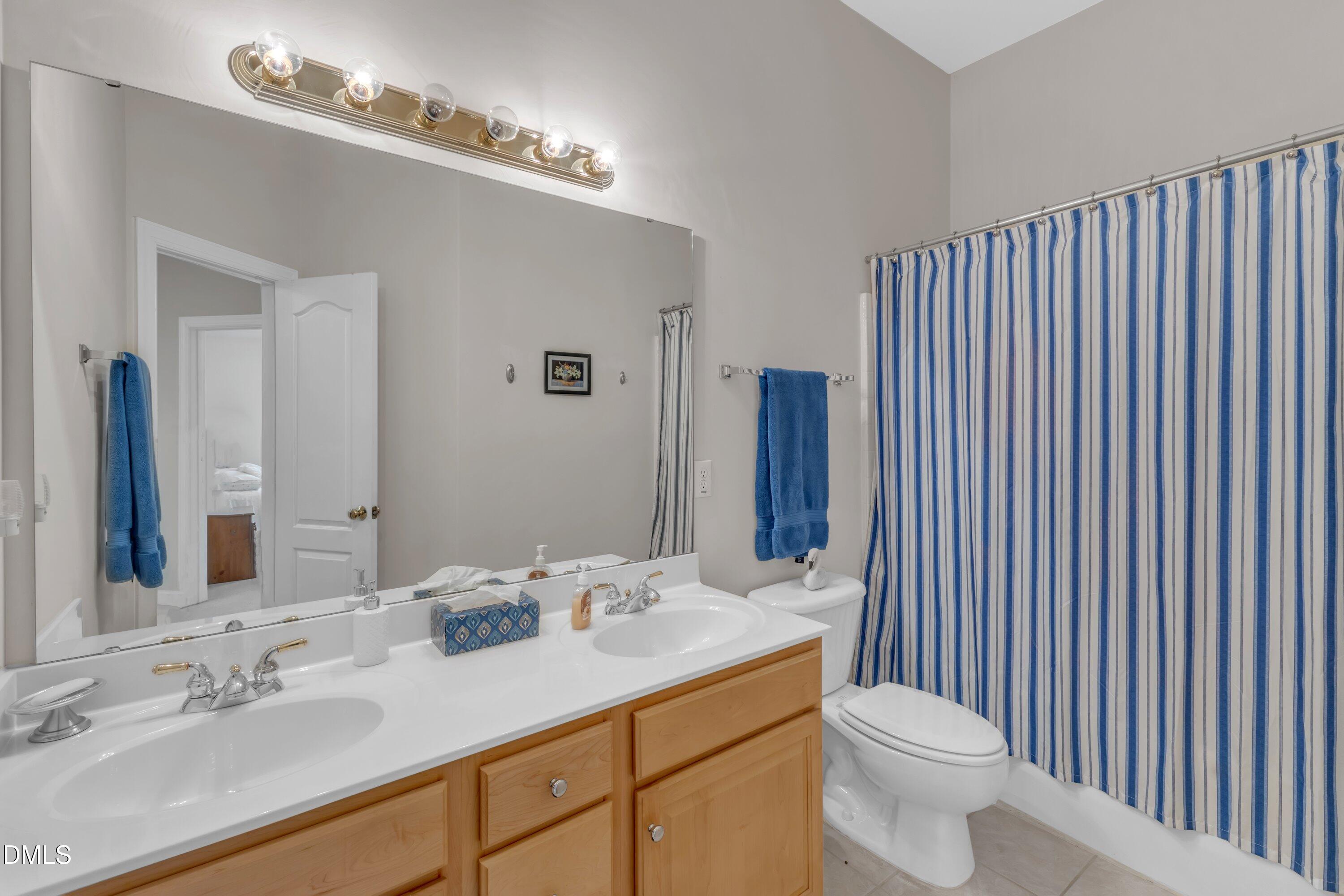 12227 Orchardgrass Lane Raleigh, NC 27614 - Photo 31 of 46 a bathroom with a double vanity sink toilet and a mirror