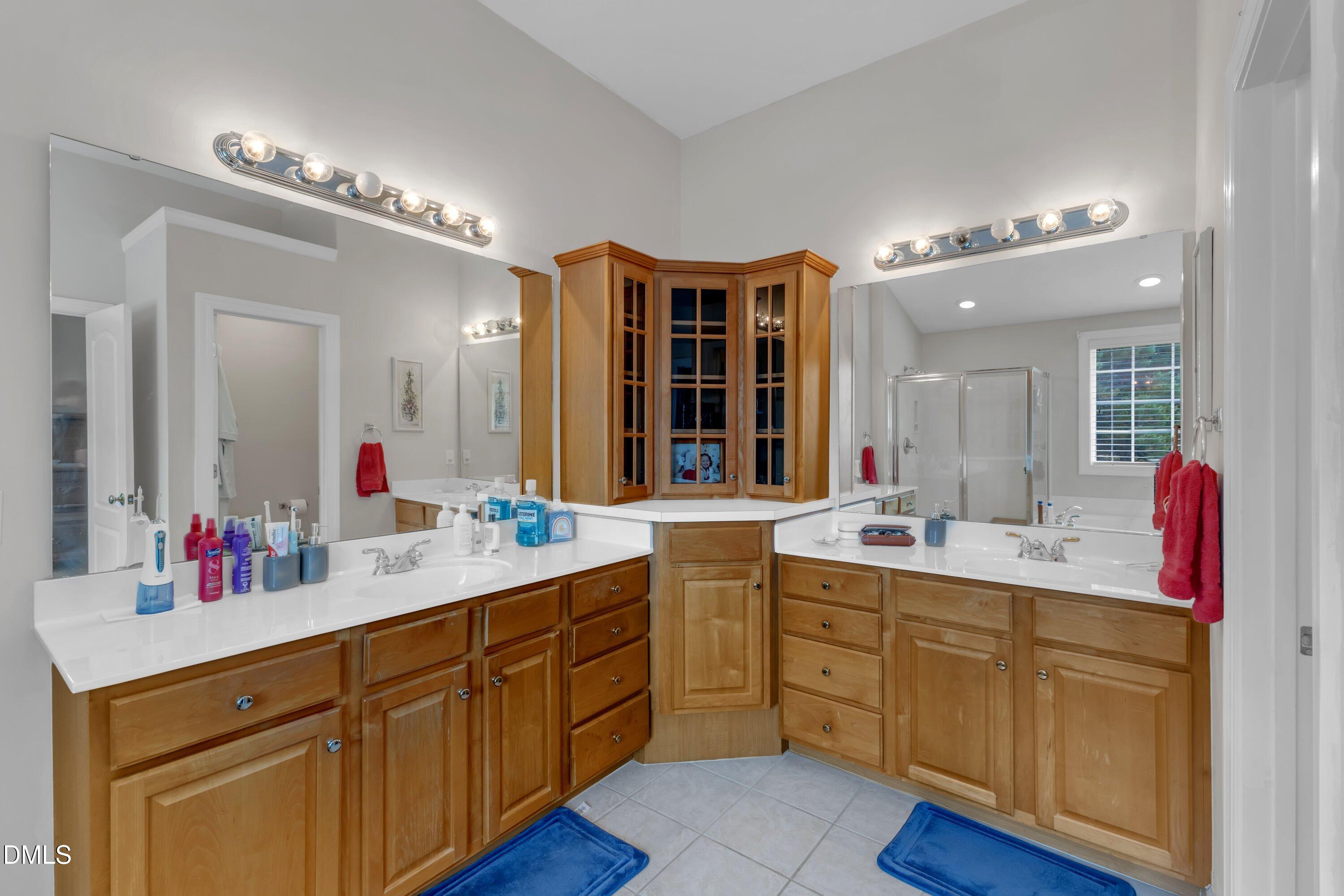 12227 Orchardgrass Lane Raleigh, NC 27614 - Photo 38 of 46 a bathroom with a double vanity sink and a mirror