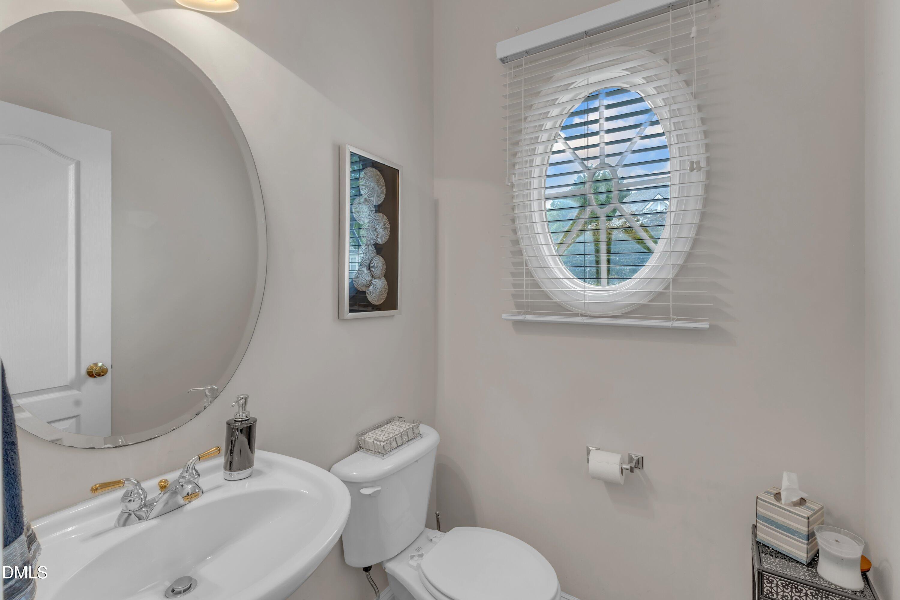 12227 Orchardgrass Lane Raleigh, NC 27614 - Photo 7 of 46 a bathroom with a toilet a sink and mirror