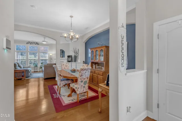 a living room with furniture a chandelier and a dining table