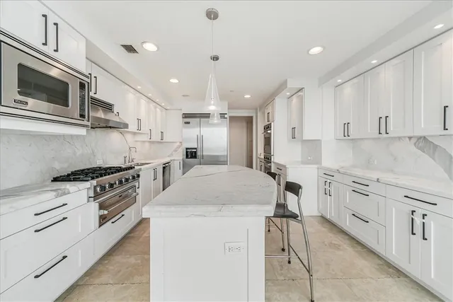 a kitchen with cabinets stainless steel appliances and a counter top space
