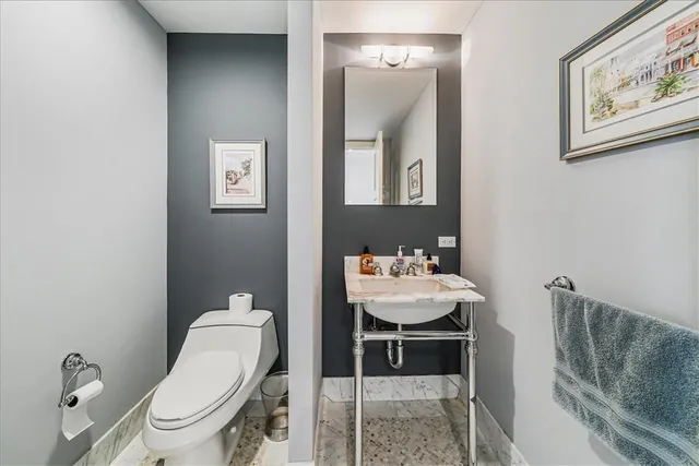 a bathroom with a toilet a sink and mirror