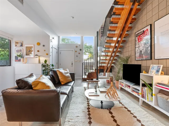 a living room with furniture a flat screen tv and a floor to ceiling window