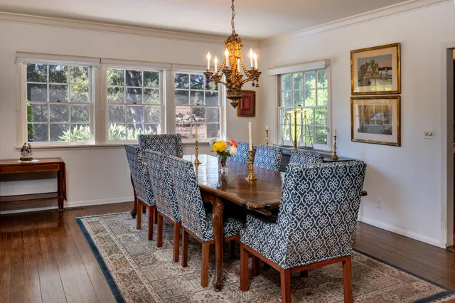 a dining room with furniture a chandelier and wooden floor