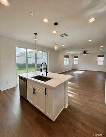 a kitchen with stainless steel appliances granite countertop a sink a stove and a wooden floors