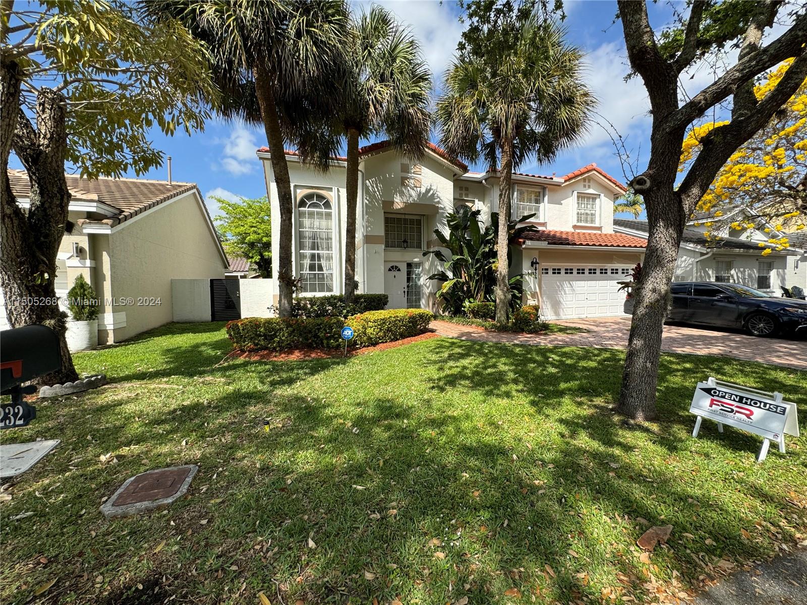 a view of a house with a small yard and tree s