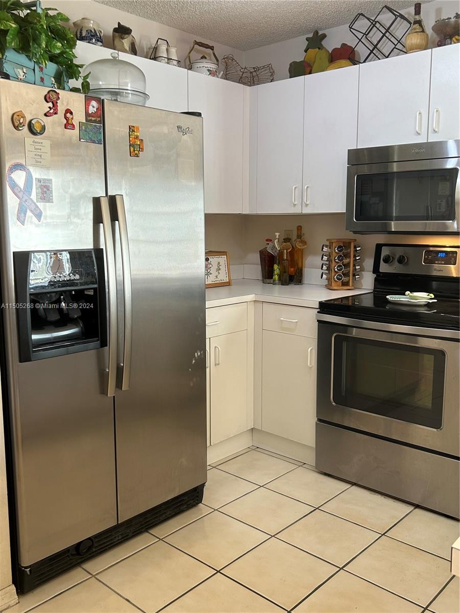 19232 Northwest 88th Place Hialeah, FL 33018 - Photo 18 of 61 a kitchen with stainless steel appliances granite countertop a refrigerator and a stove top oven