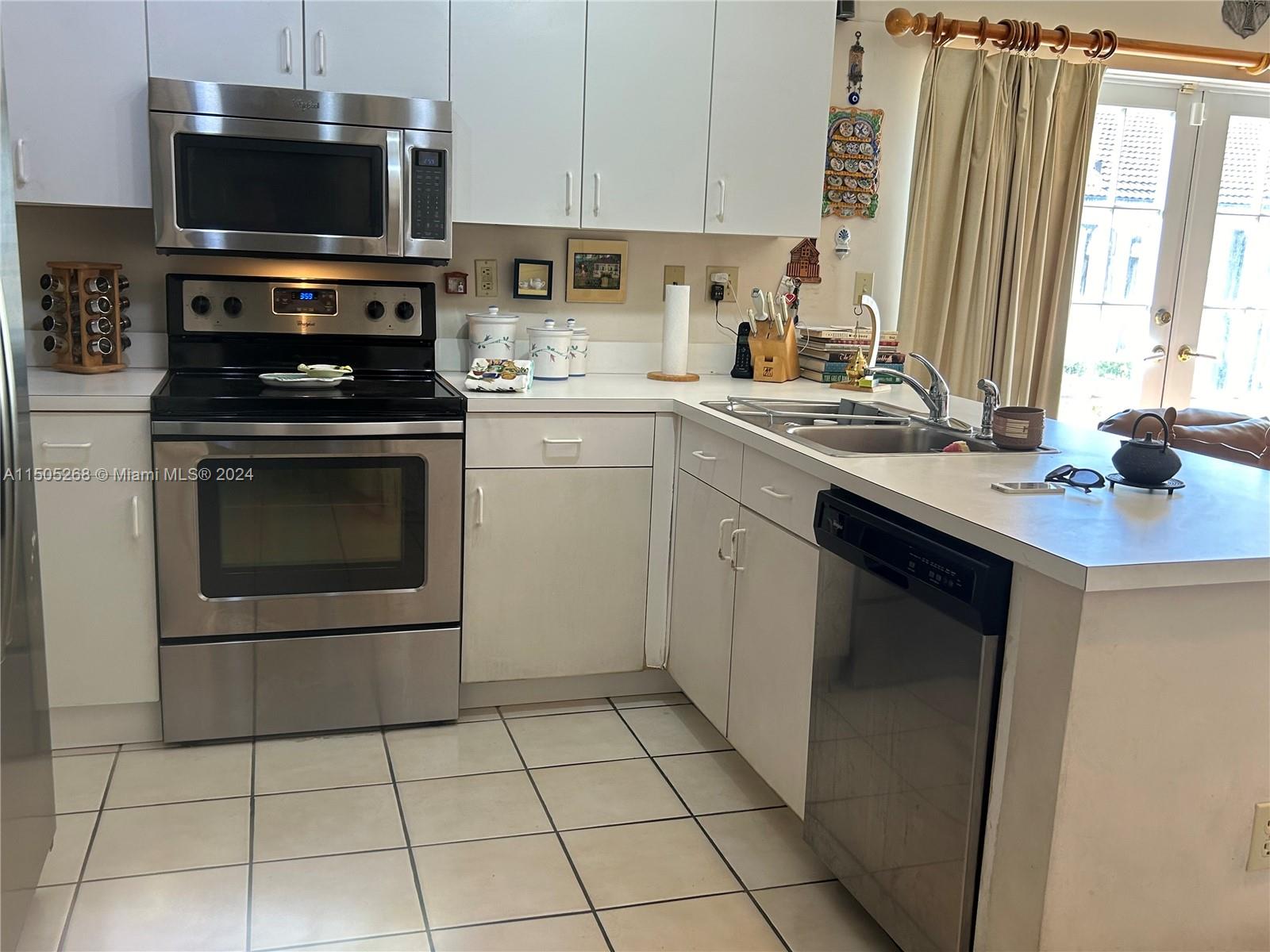 19232 Northwest 88th Place Hialeah, FL 33018 - Photo 20 of 61 a kitchen with stainless steel appliances a stove a sink and a microwave
