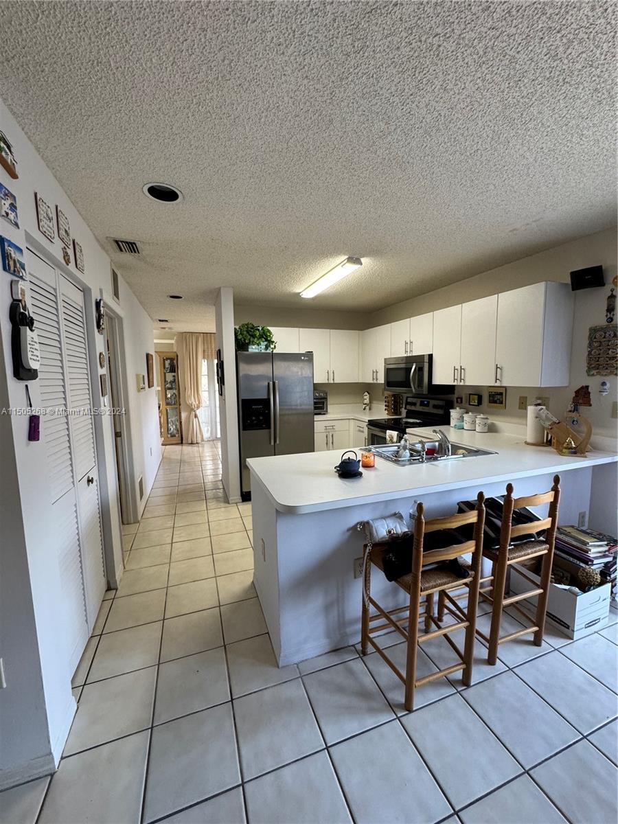 19232 Northwest 88th Place Hialeah, FL 33018 - Photo 21 of 61 a kitchen with stainless steel appliances a sink a counter top space and cabinets