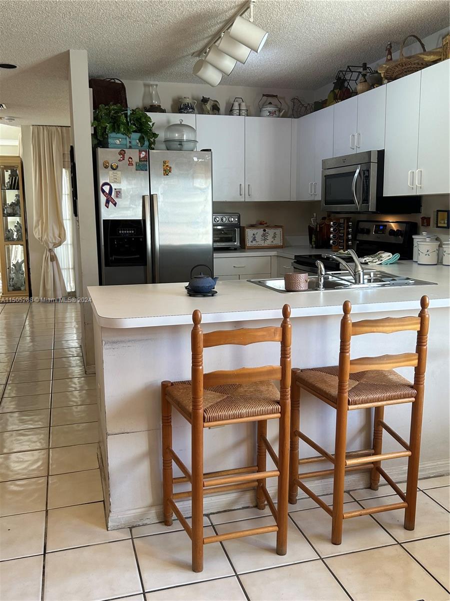 19232 Northwest 88th Place Hialeah, FL 33018 - Photo 22 of 61 a kitchen with stainless steel appliances kitchen island granite countertop a refrigerator and microwave