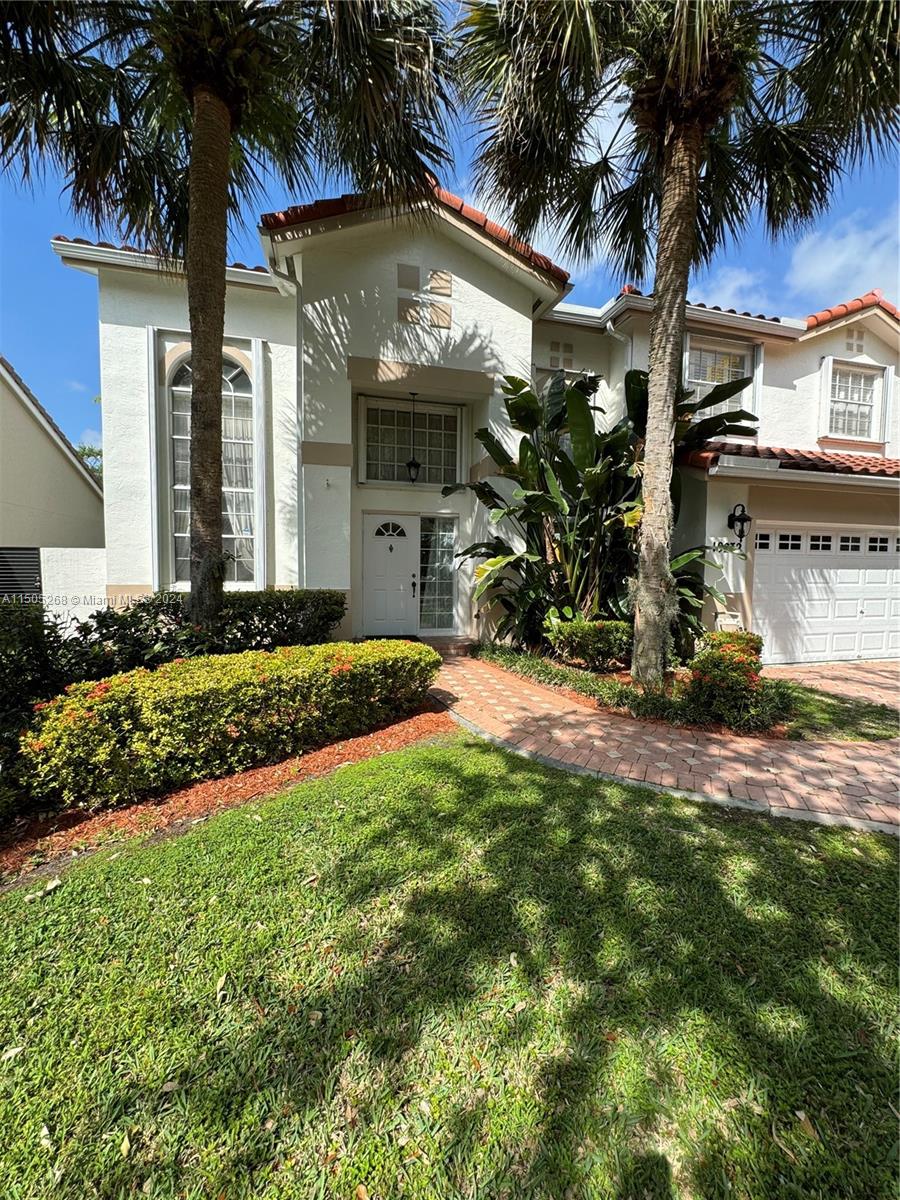 19232 Northwest 88th Place Hialeah, FL 33018 - Photo 3 of 61 a front view of a house with a yard