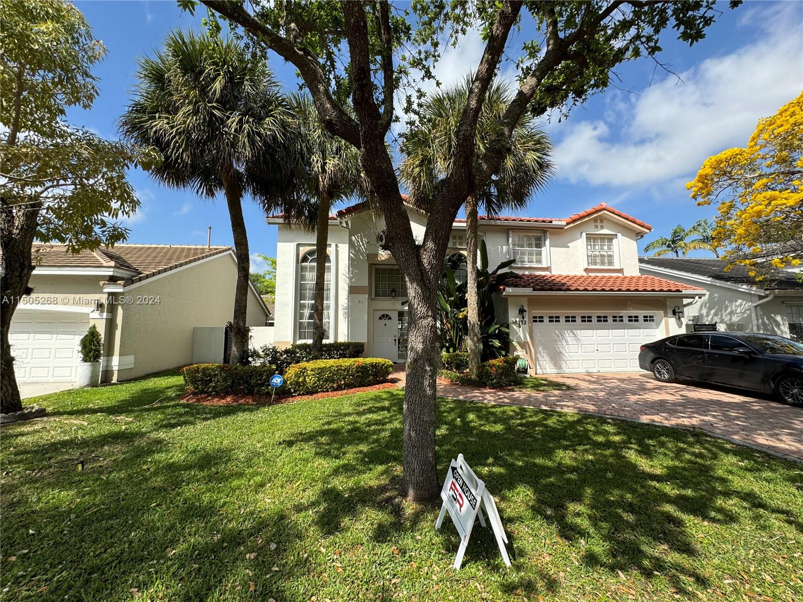 19232 Northwest 88th Place Hialeah, FL 33018 - Photo 4 of 61 a front view of a house with a yard