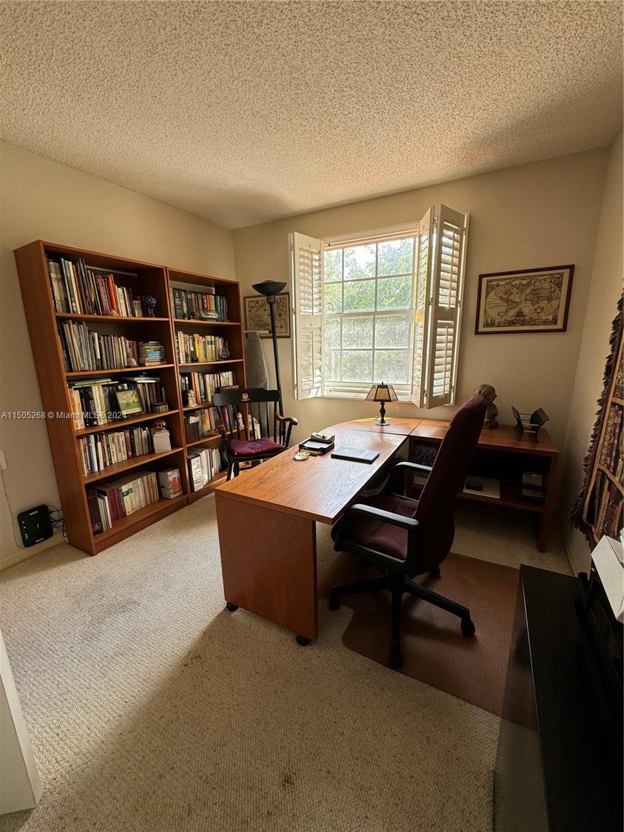 19232 Northwest 88th Place Hialeah, FL 33018 - Photo 45 of 61 a living room with furniture a bookshelf and a large window
