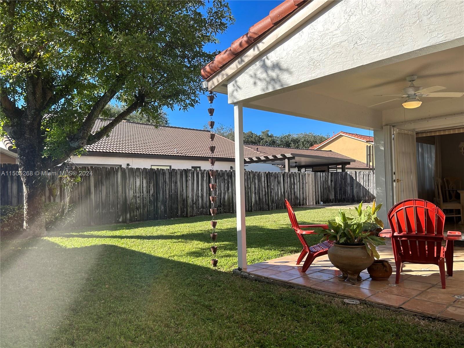 19232 Northwest 88th Place Hialeah, FL 33018 - Photo 54 of 61 a backyard of a house with table and chairs