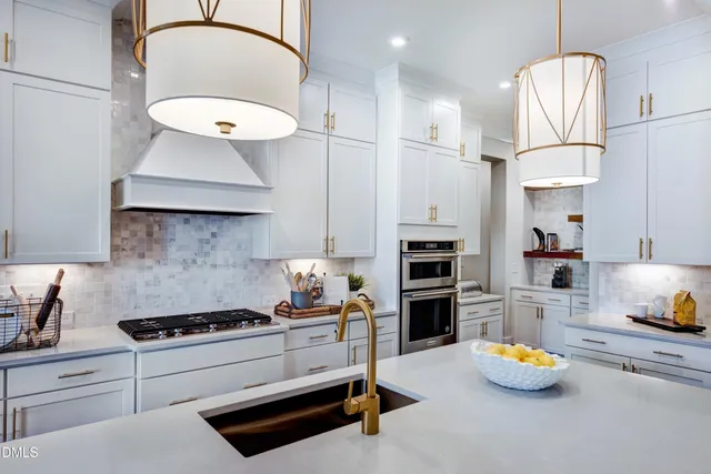 a kitchen with kitchen island granite countertop a sink a center island stainless steel appliances and cabinets