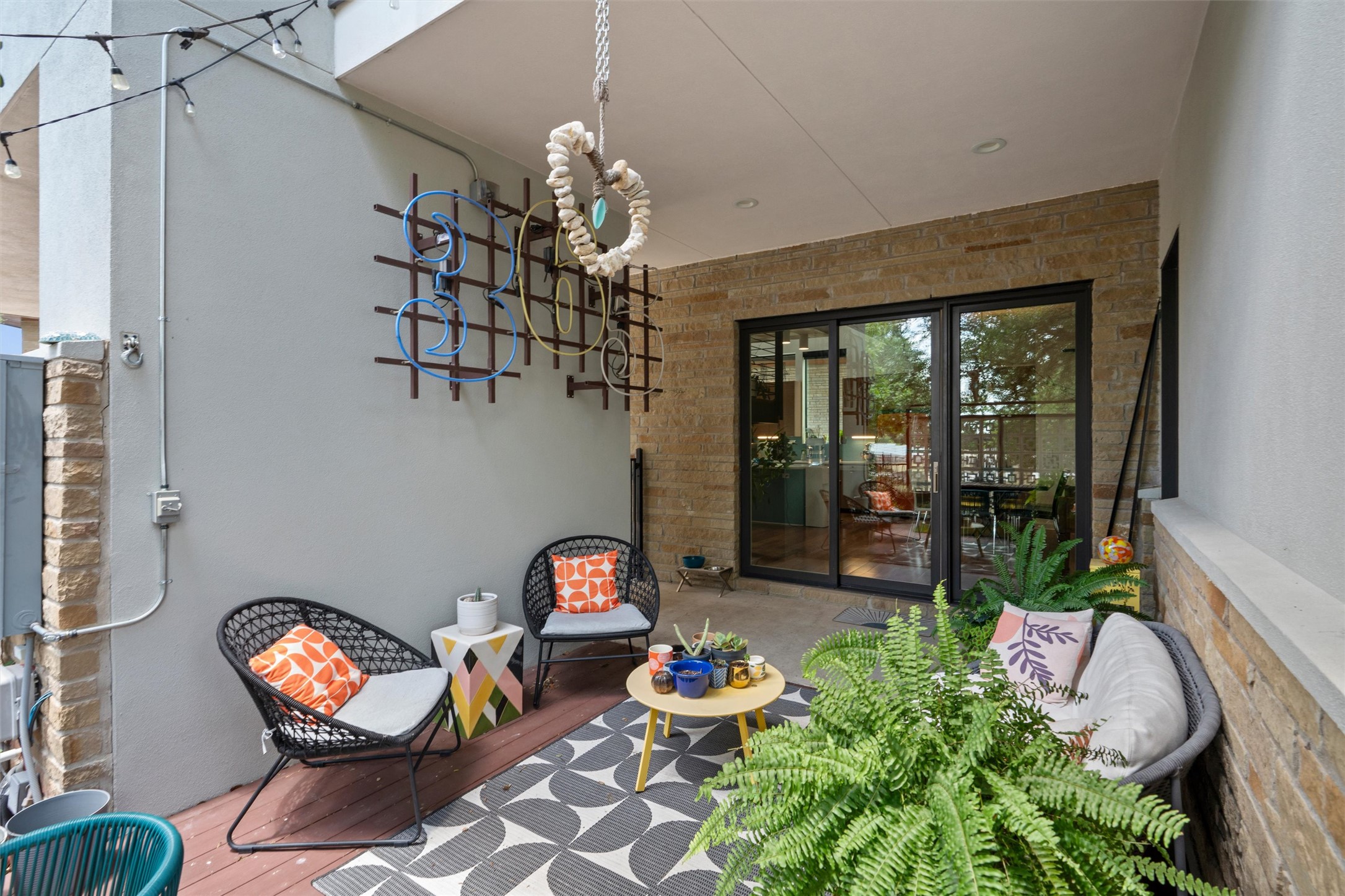 408 Starlight Village Loop Leander, TX 78641 - Photo 14 of 40 An inviting outdoor patio, framed by stacked stone, features comfortable seating and lively wall art.