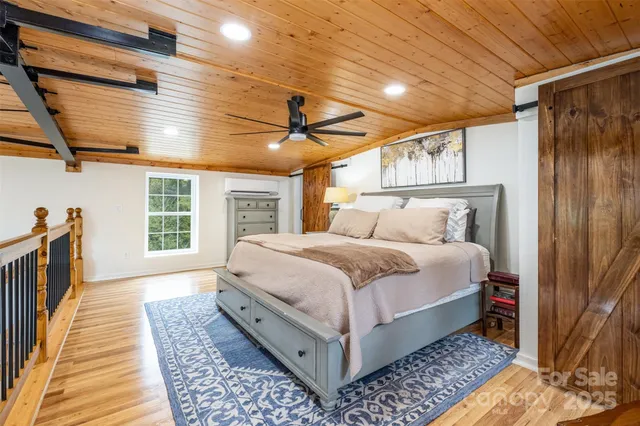 a bedroom with a bed wooden floor and a window