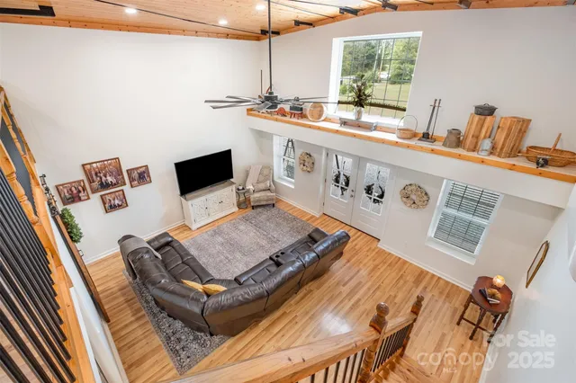 a living room with a bed furniture and a flat screen tv