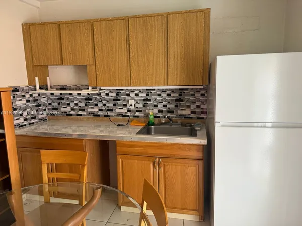 a bathroom with a sink and a refrigerator