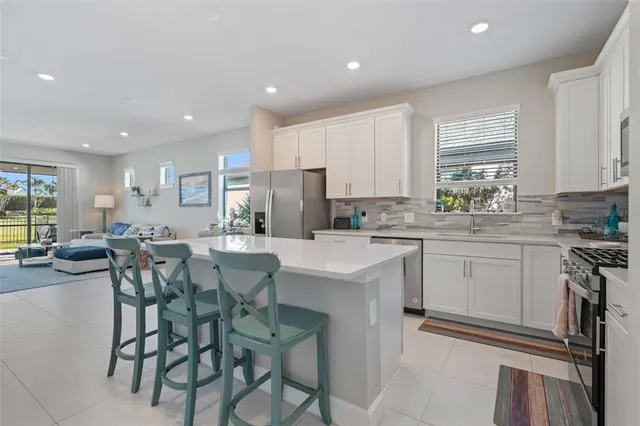 a kitchen with appliances a sink a counter top space and a center island