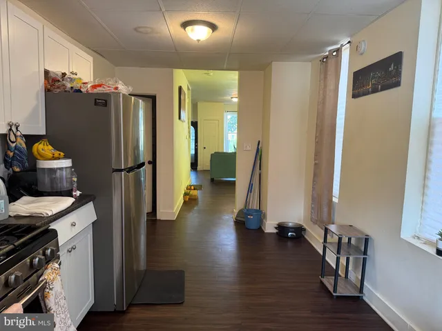a kitchen with a refrigerator and wooden floor