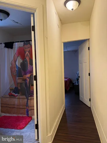 a view of a hallway with wooden floor and closet