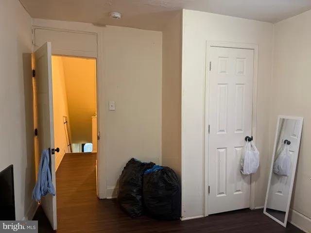 a view of hallway with wooden floor and closet