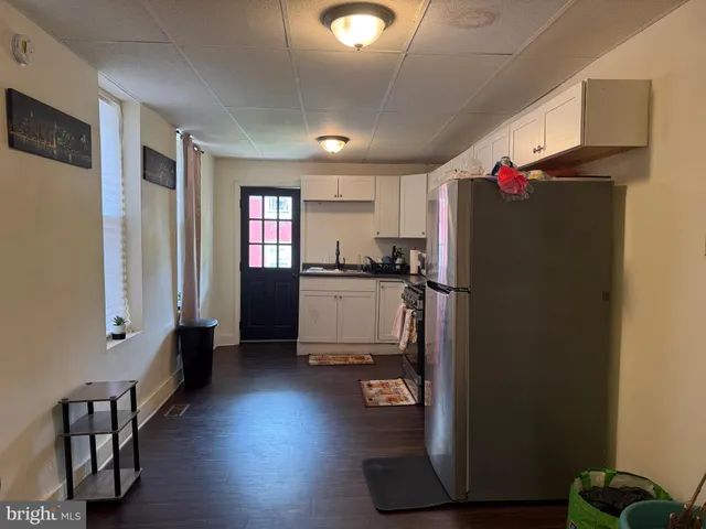 a kitchen with granite countertop a refrigerator and a stove top oven
