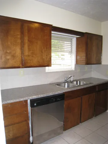 a kitchen with granite countertop cabinets sink and a window