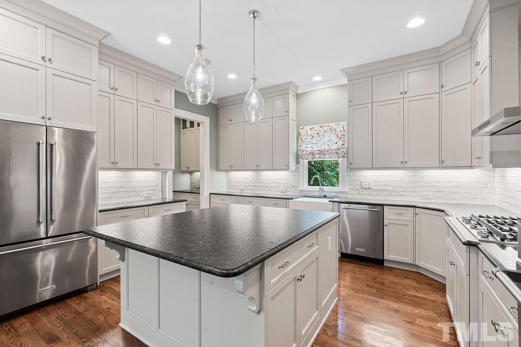 516 Sasser Street Raleigh, NC 27604 - Photo 13 of 30 a kitchen with kitchen island granite countertop a sink a counter space appliances and cabinets