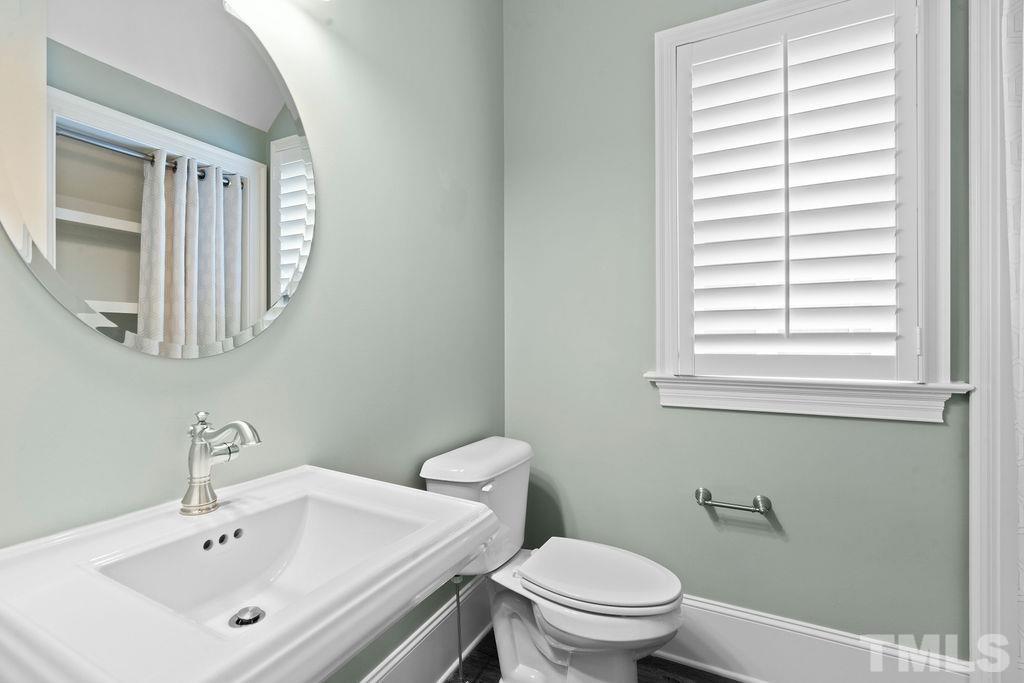 516 Sasser Street Raleigh, NC 27604 - Photo 17 of 30 a bathroom with a sink a toilet and a mirror