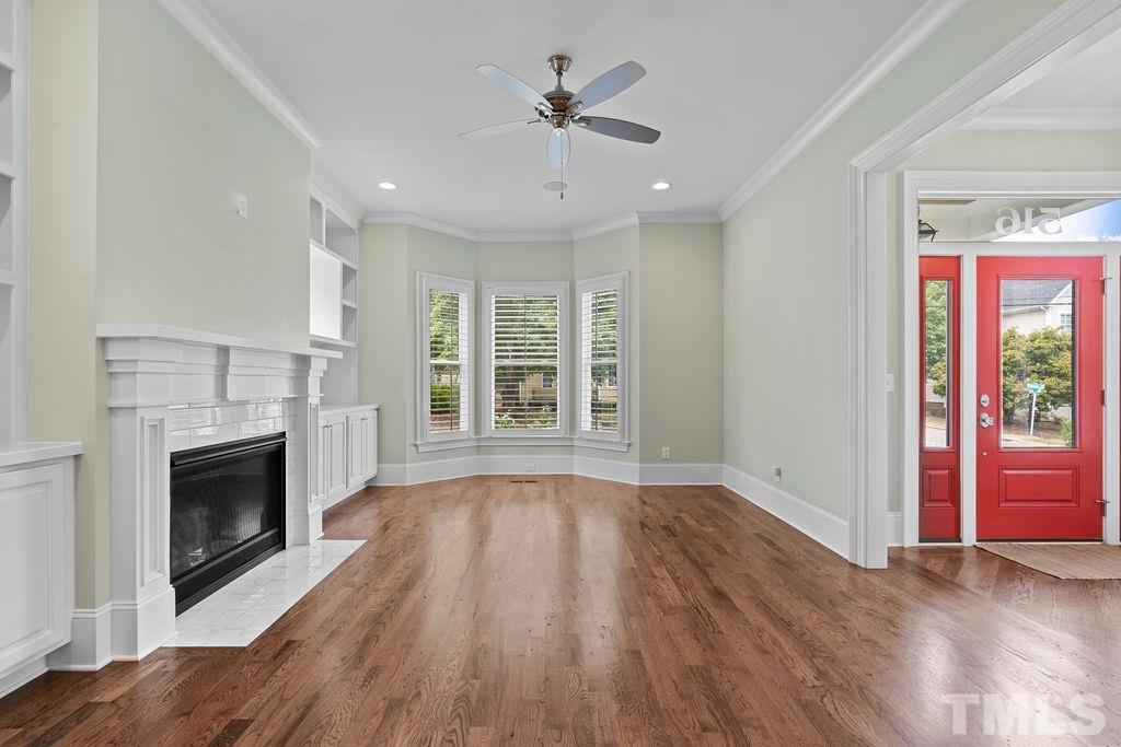 516 Sasser Street Raleigh, NC 27604 - Photo 8 of 30 an empty room with windows a fireplace and wooden floor