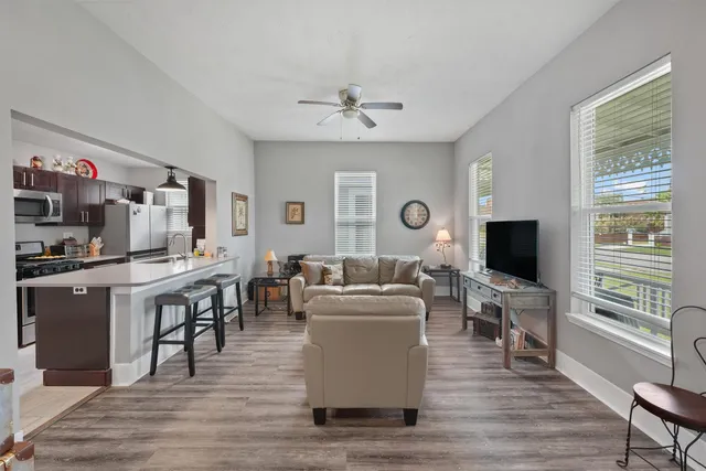 a living room with furniture a flat screen tv and wooden floor