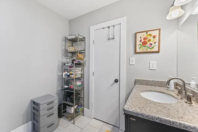 a bathroom with a granite countertop sink and a toilet
