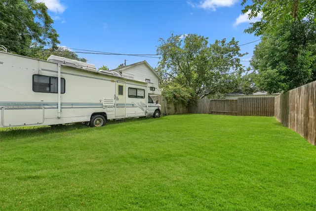 a bus parked in front of a house with a big yard