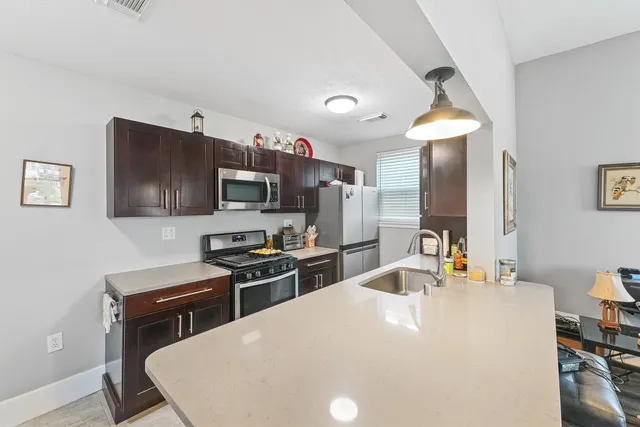 a kitchen with stainless steel appliances a stove a sink a microwave and refrigerator