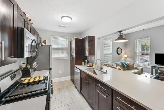 a kitchen with stainless steel appliances granite countertop a sink stove and refrigerator
