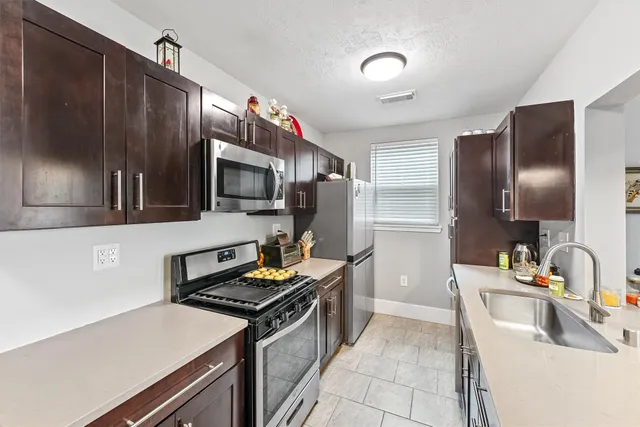 a kitchen that has a sink stainless steel appliances and cabinets