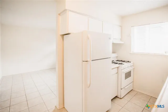 a white refrigerator freezer sitting inside of a kitchen