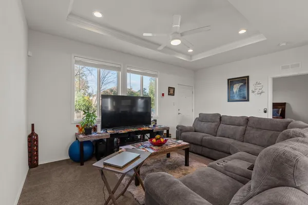a living room with furniture and a view of kitchen