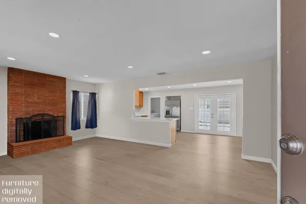 a view of an empty room with a fireplace and a window