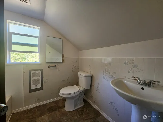 a bathroom with a sink a toilet and a mirror