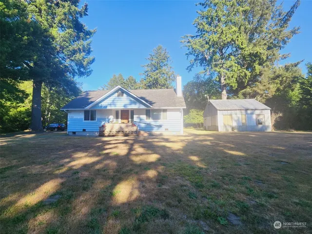 a front view of a house with yard and tree s