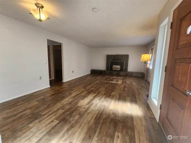 a view of a hallway with wooden floor and a fireplace