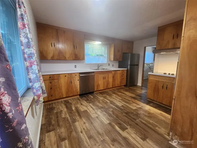 a view of a kitchen with wooden floor and electronic appliances