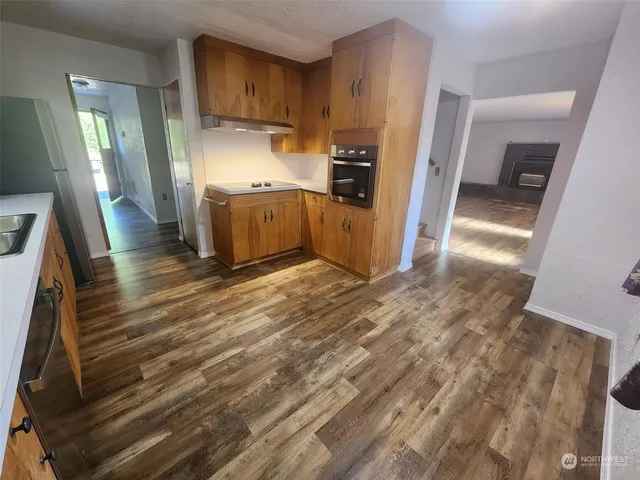 a kitchen with stainless steel appliances kitchen island granite countertop a refrigerator and a sink