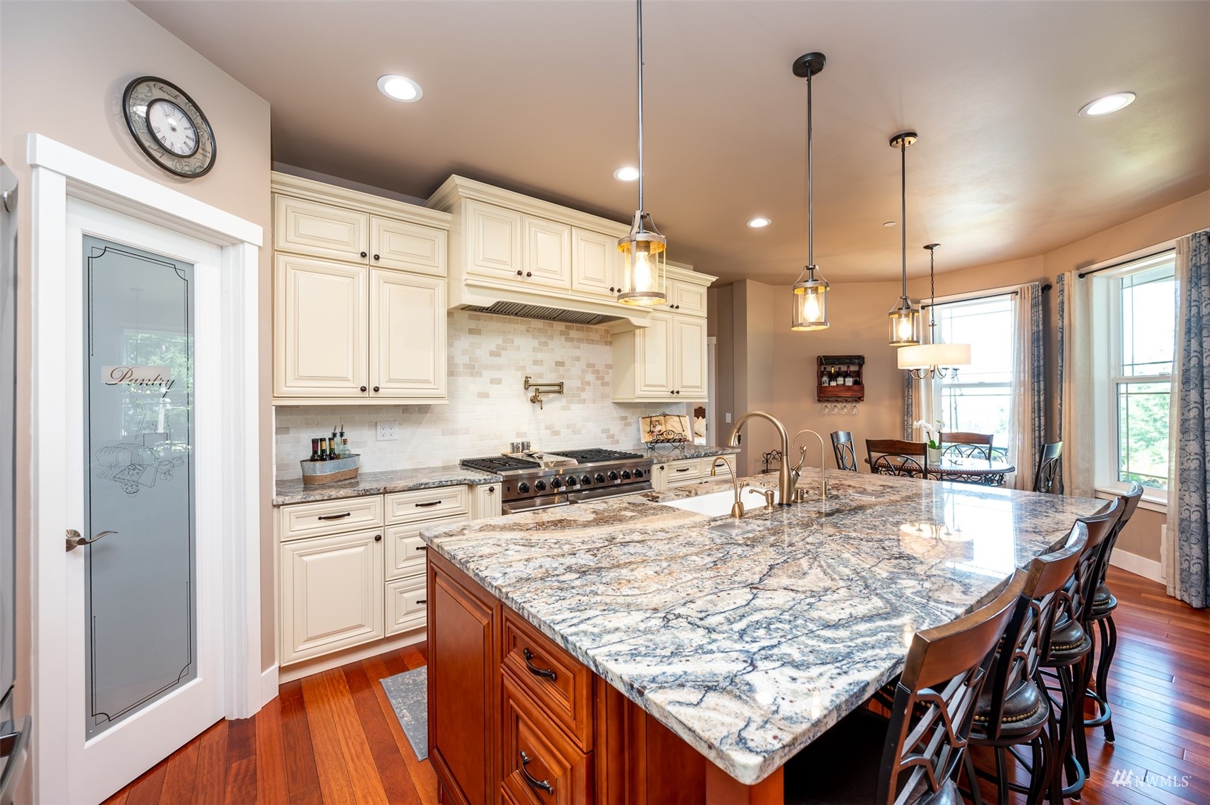 25920 80th Avenue East Graham, WA 98338 - Photo 11 of 40 a kitchen with kitchen island granite countertop wooden cabinets and refrigerator